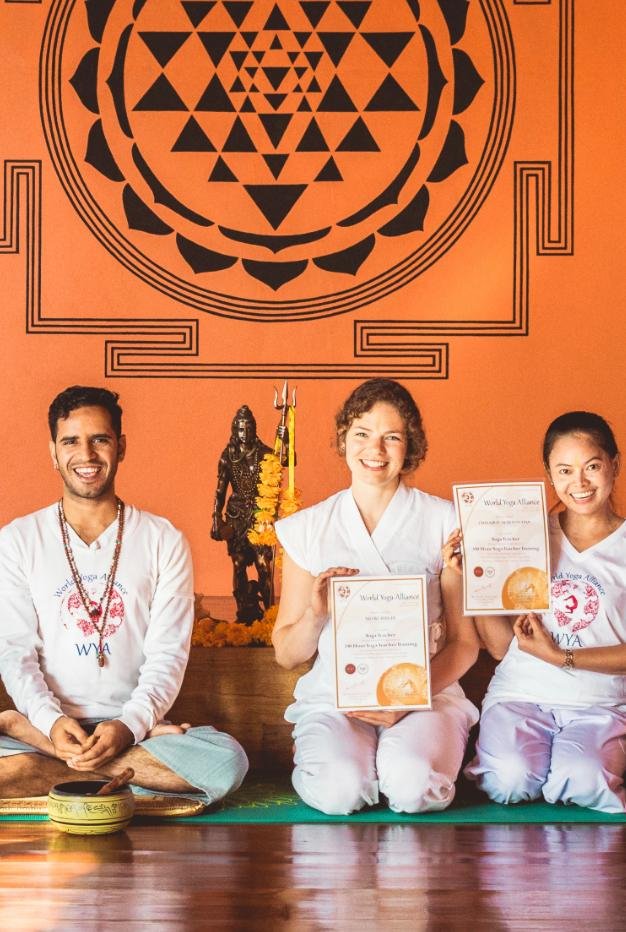 Tarin holding her yoga teacher training certificate